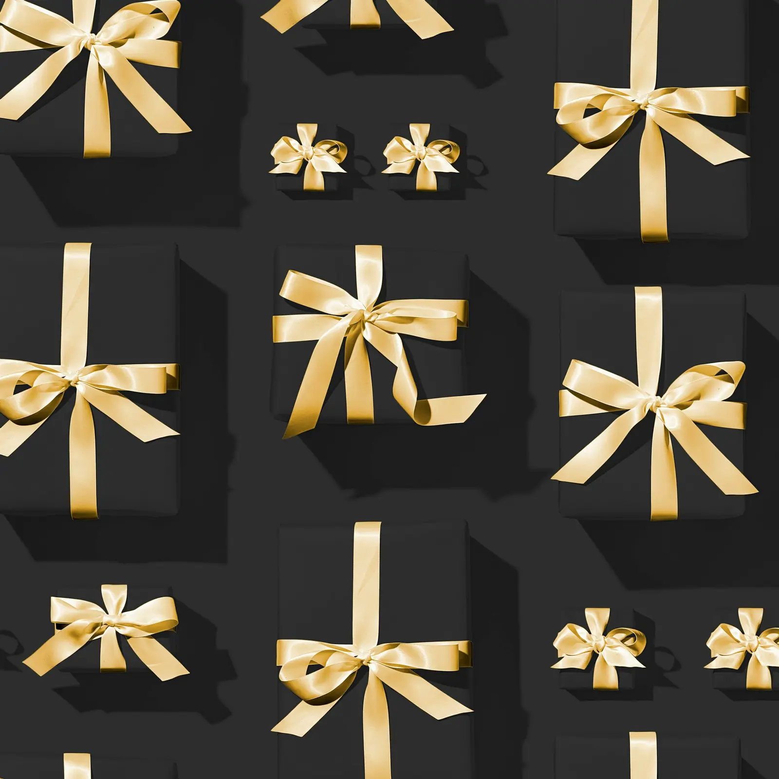 Black gift boxes tied with gold satin ribbon